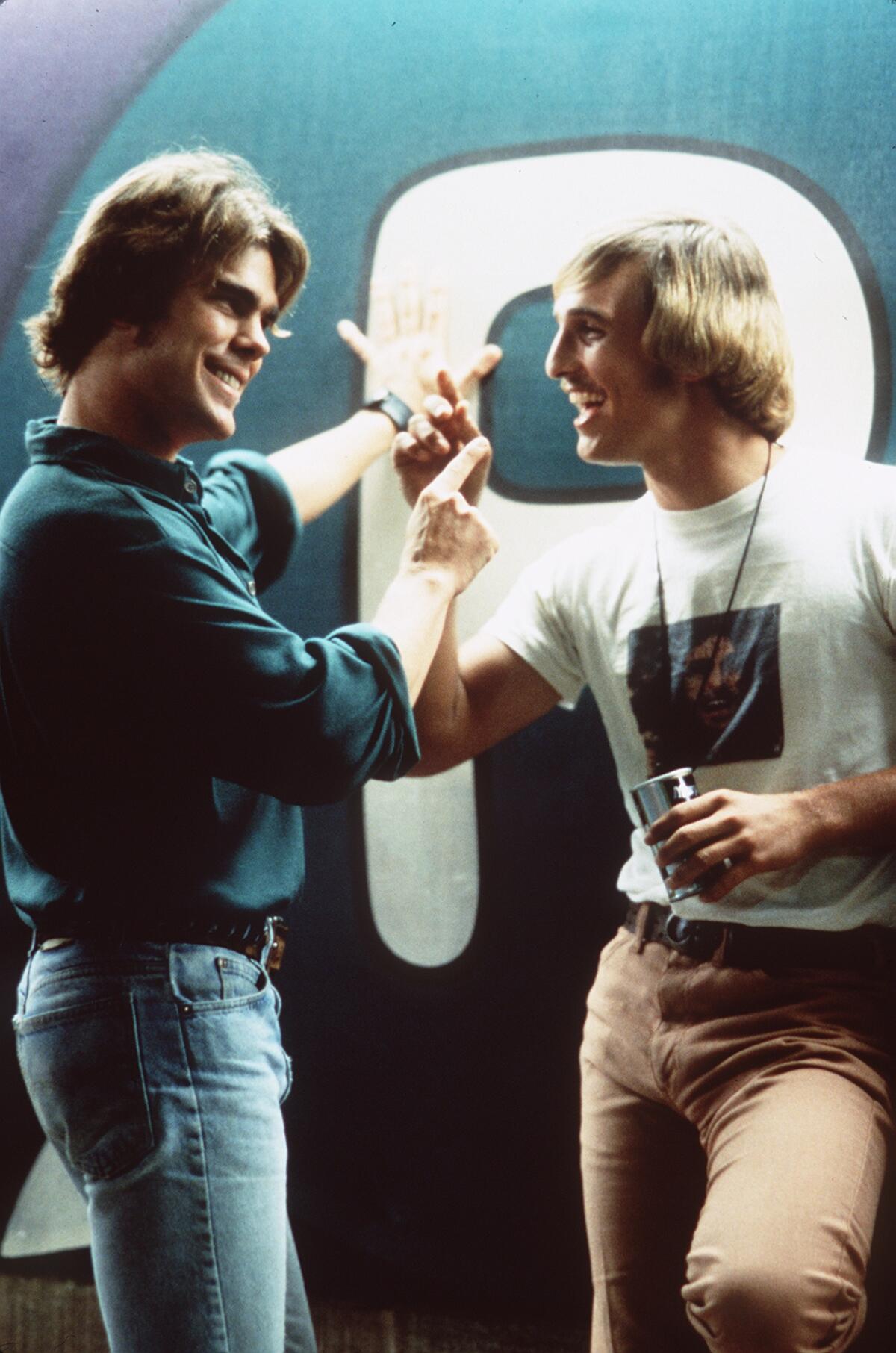 Two young men chat outside a pool hall.
