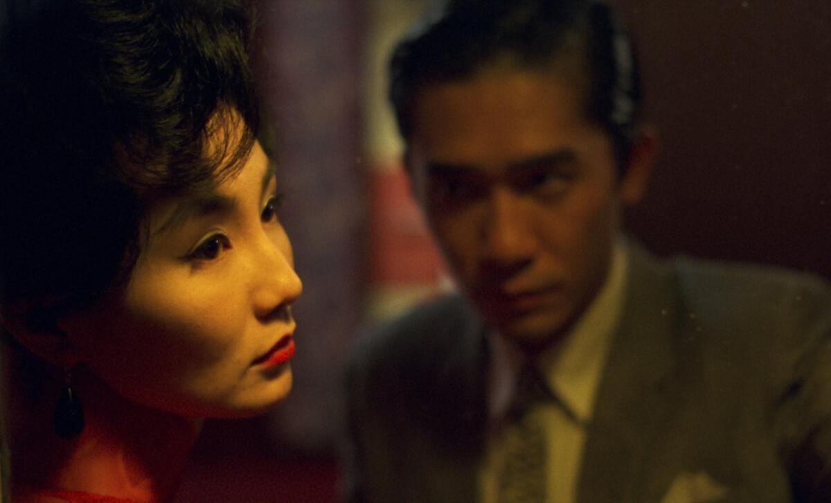 A man stares intensely at a glamorous woman.