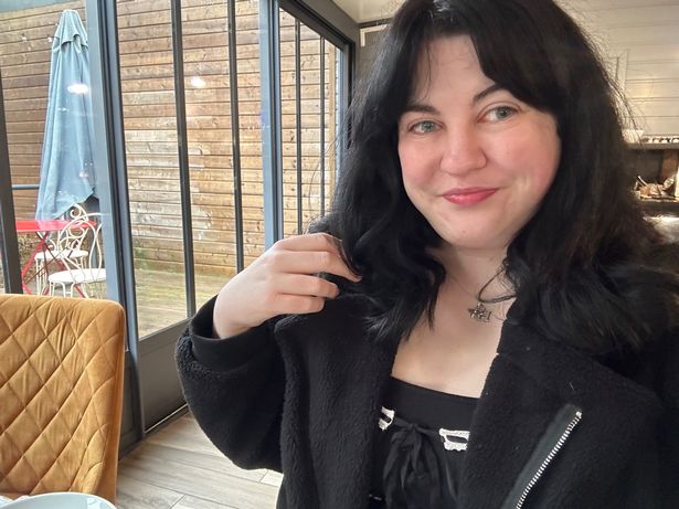 A woman with dark hair and a dark jacket looking directly at the camera
