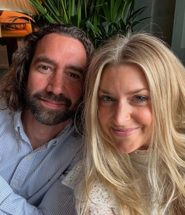 Anna Williamson, in a white top, taking a selfie with her husband Alex Di Pasquale, in a blue shirt.