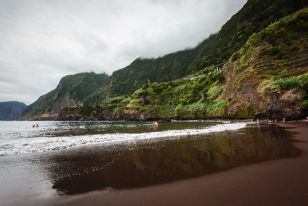 Picture taken in broad daylight by a cloudy in the middle of the black sand beach called "Praia do Porto" in Seixal, Madeira.