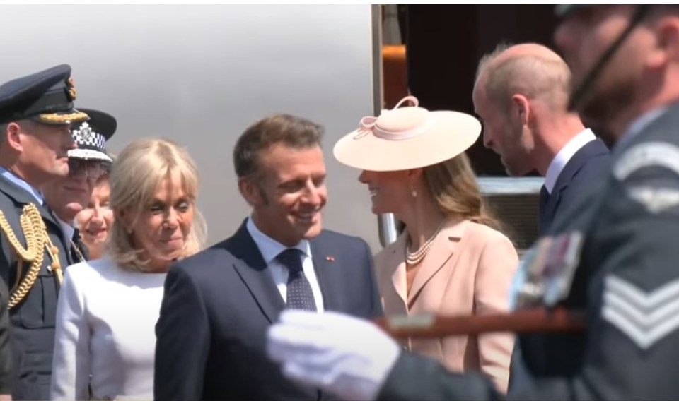 Brigitte and Emmanuel Macron greeting someone.