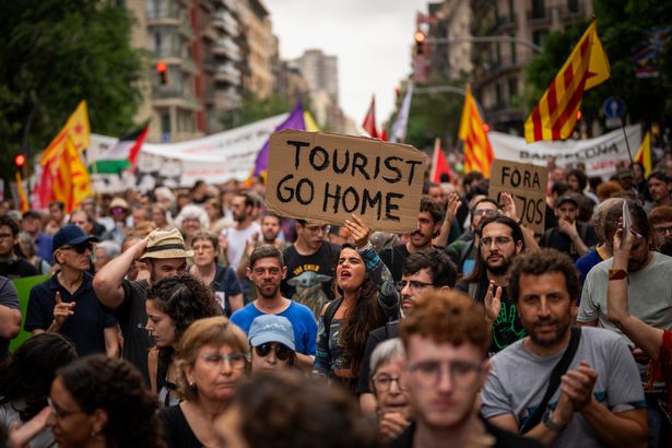 Demonstrators march shouting slogans against the Formula 1 Barcelona Fan Festival in downtown Barcelona, Spain