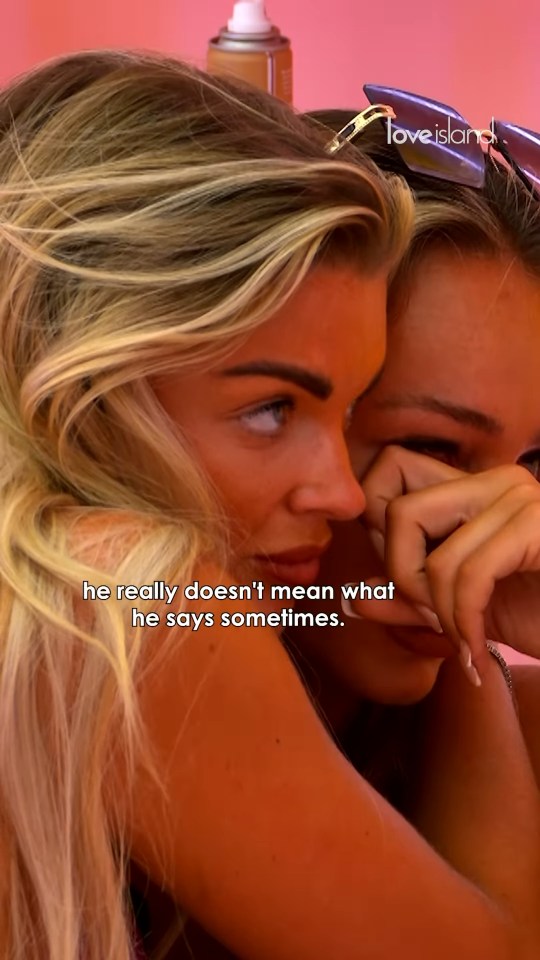Two women embracing, one comforting the other who is crying.