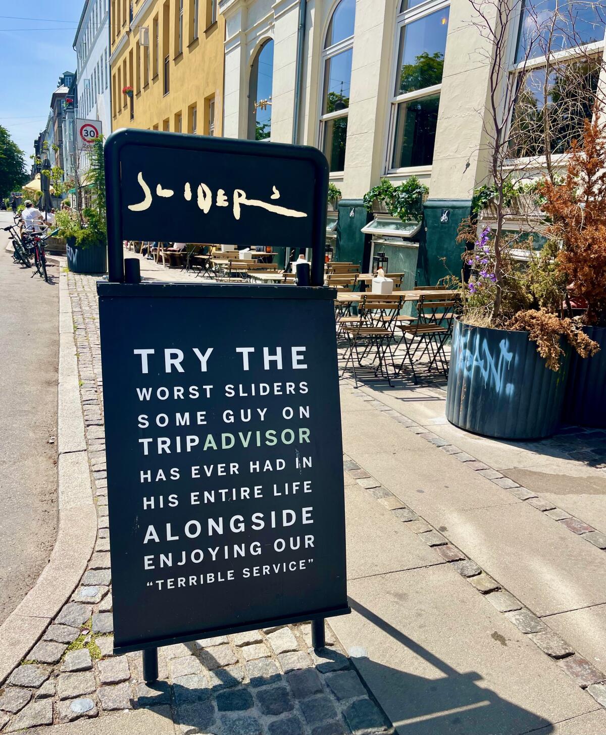 A sign outside of Sliders in Copenhagen reads in part, "Try the worst sliders some guy on Tripadvisor has ever had ..."