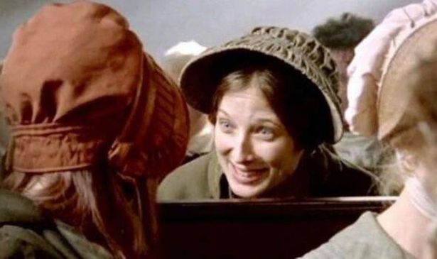 A woman in a bonnet talks to another woman
