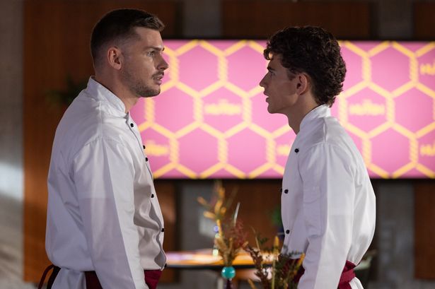 Two men in white shirts looking at each other

