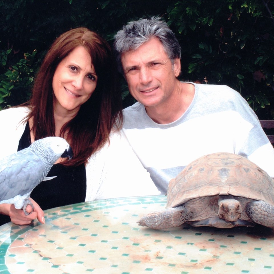 Photo of Robin Kaye and Thomas Deluca with a parrot and tortoise.