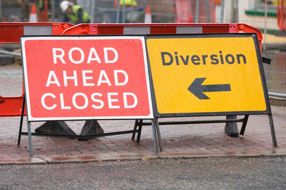 Road closed sign with diversion arrow.