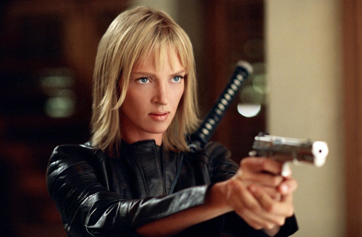 A steely woman points a pistol.
