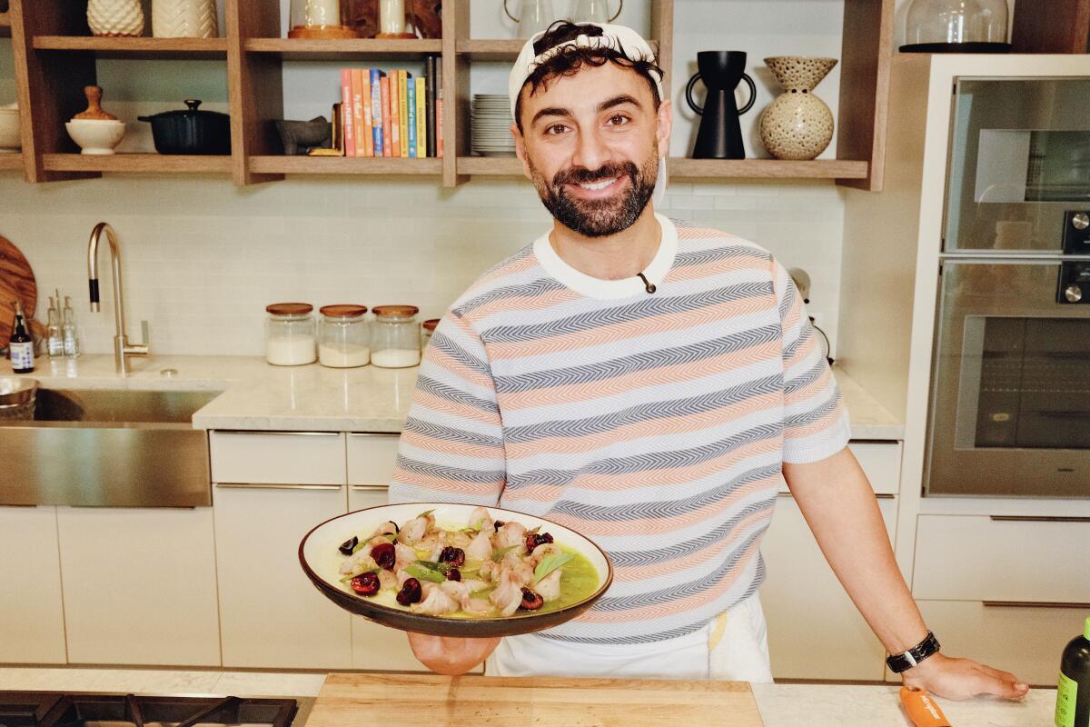 El Segundo,CA-July 15: Cento Raw Bar chef Avner Levi holds hamachi crudo with cherries and jalapeno, L.A. Times kitchen