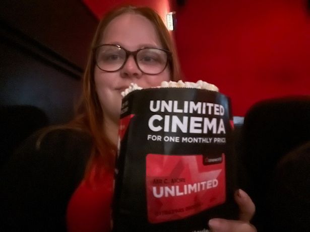 Reporting Alice holding a cinema bag of popcorn