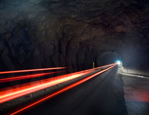 Traffic streaming out of  tunnel at night
