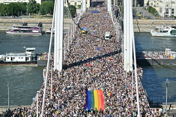 *** BESTPIX *** People carry a Rainbow flag as they take part in the Budapest Pride parade in Budapest downtown on June 28, 2025, as the capital's municipality organised this march by the LGBTQ community, celebrating freedom, in a move to circumvent a law that allows police to ban LGBTQ marches. Hungary's Prime Minister had announced that police will not "break up" Saturday's Budapest Pride march despite issuing a ban, but warned attendees and organisers about the legal consequences. His ruling coalition amended laws and the constitution earlier this year to prohibit the annual celebration, advancing his widely condemned, years-long clampdown on LGBTQ rights in the name of "child protection". (Photo by Attila KISBENEDEK / AFP) (Photo by ATTILA KISBENEDEK/AFP via Getty Images)