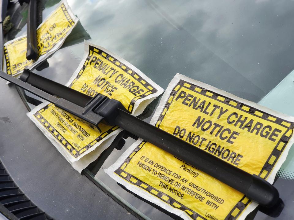 Three parking tickets on a car windshield.