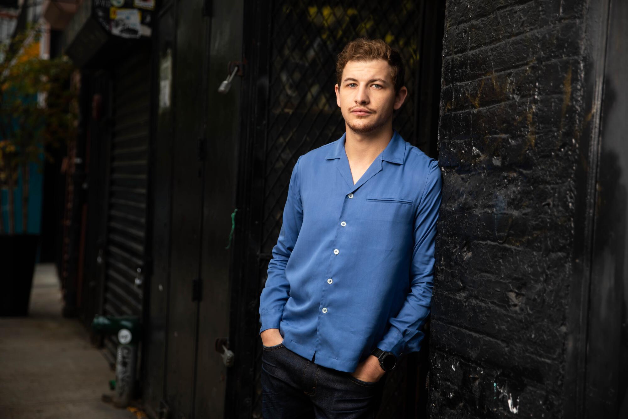 A man in a blue top poses for the camera.