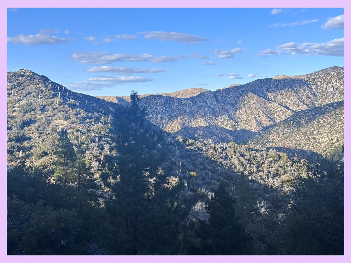 Overlook of mountains and hills with a variety of cloud and shade cover.