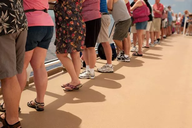 Image of line of people looking out over the deck of a cruise ship