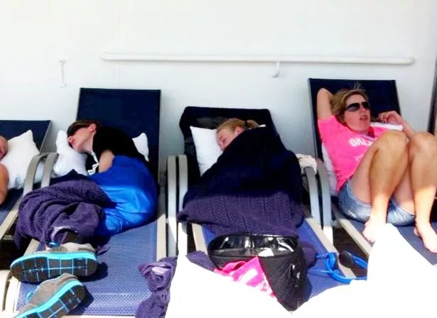 Image of passengers lying on deck chairs fully clothed  on Carnival Triumph cruise ship in 2013 after electrical failure