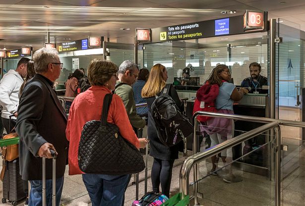 People queue for the customs security check at Barcelona airport