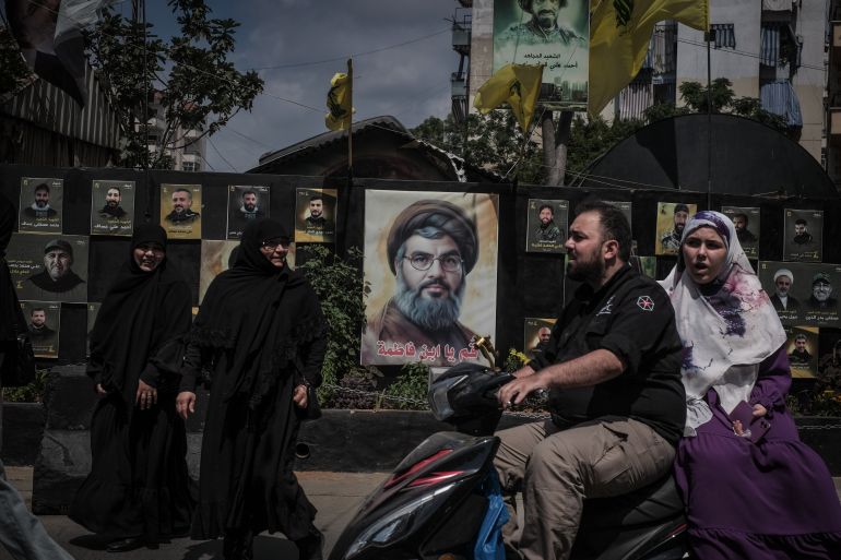 A busy street in Hay El Selom, decorated by posters of Hezbollah martyrs, including the late leader of the organisation, Sayyed Hassan Nasrallah, where Fatima and her two sons used to live before their home was destroyed by an Israeli airstrike in 2024 [João Sousa/Al Jazeera]