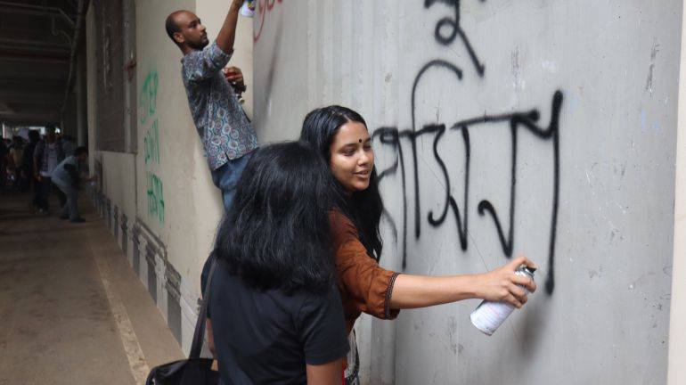 Protesters drawing graffiti, writing slogans against Sheikh Hasina on the walls of Dhaka [Masum Billah/Al Jazeera]