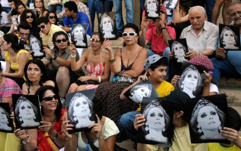 In this photo taken Monday, July 26, 2010, fans of Lebanese diva Fairouz hold her pictures as they protest against a ban preventing her from performing songs composed by "The Rahbani Brothers," as family heirs fight over inheritance and property rights, in Beirut, Lebanon. For four decades, Lebanese singer Fairouz has performed on the world's most prestigious stages, moving audiences to tears with songs of freedom, justice and love throughout 15-years of civil war. Now, a bitter family dispute over inheritance, song royalties and intellectual property rights is threatening to silence Lebanon's most beloved diva, who is now 75-years old, and fans are outraged, and marching in the streets to ask her to keep singing. (AP Photo/Ahmad Oma