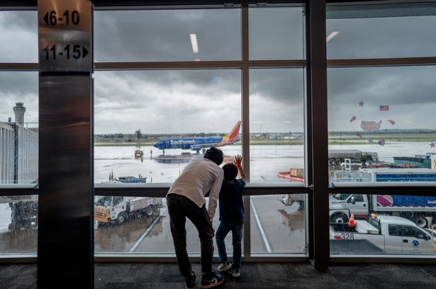AUSTIN, TEXAS - JULY 03: A family looks out towards the tarmac ahead of departure at Austin-Bergstrom International Airport on July 03, 2025 in Austin, Texas. AAA Travel is forecasting a record high of approximately 72.2 million people traveling at least 50 miles from home over the upcoming fourth of July weekend.  (Photo by Brandon Bell/Getty Images) *** BESTPIX ***