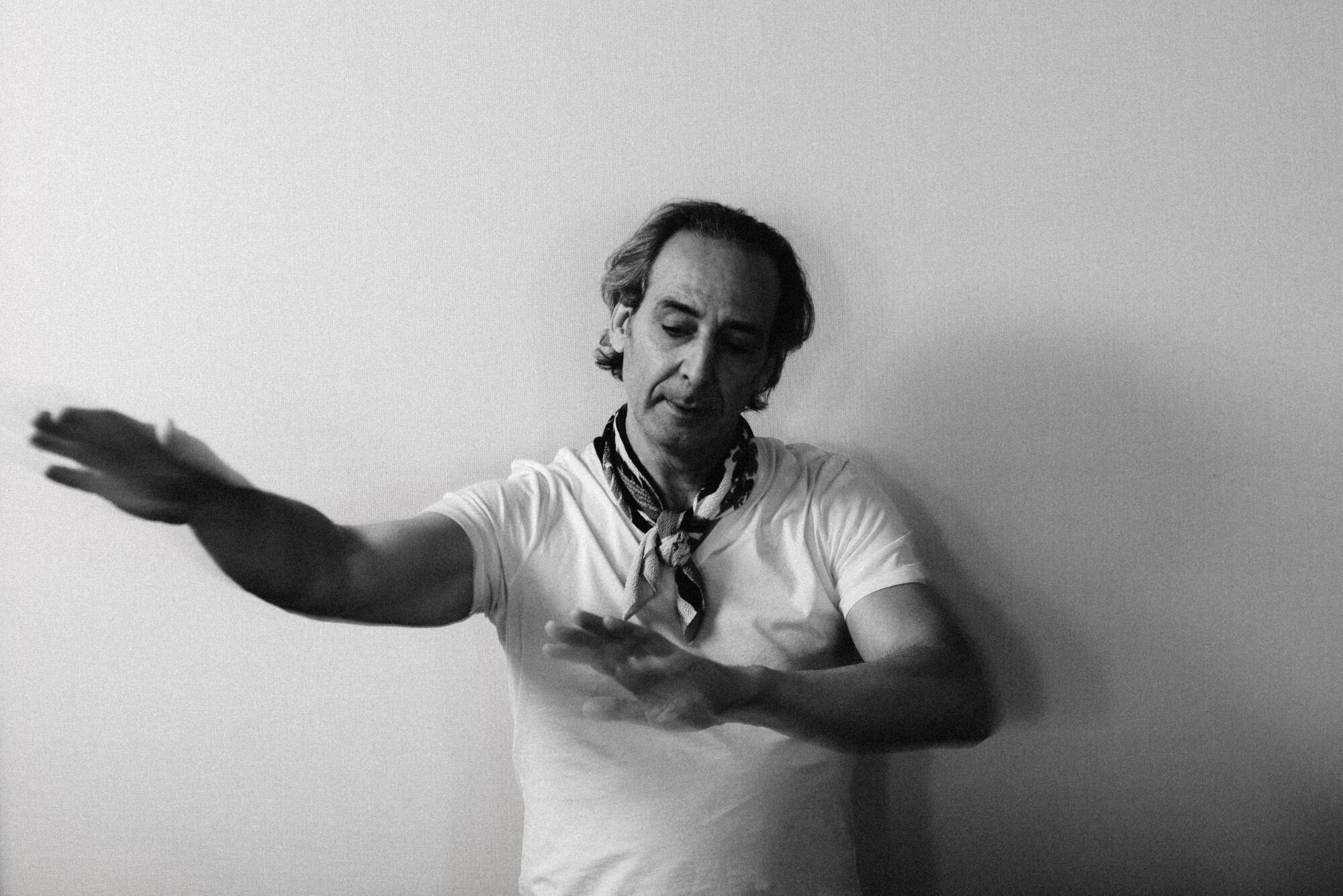 A conductor makes a shape with his hands.