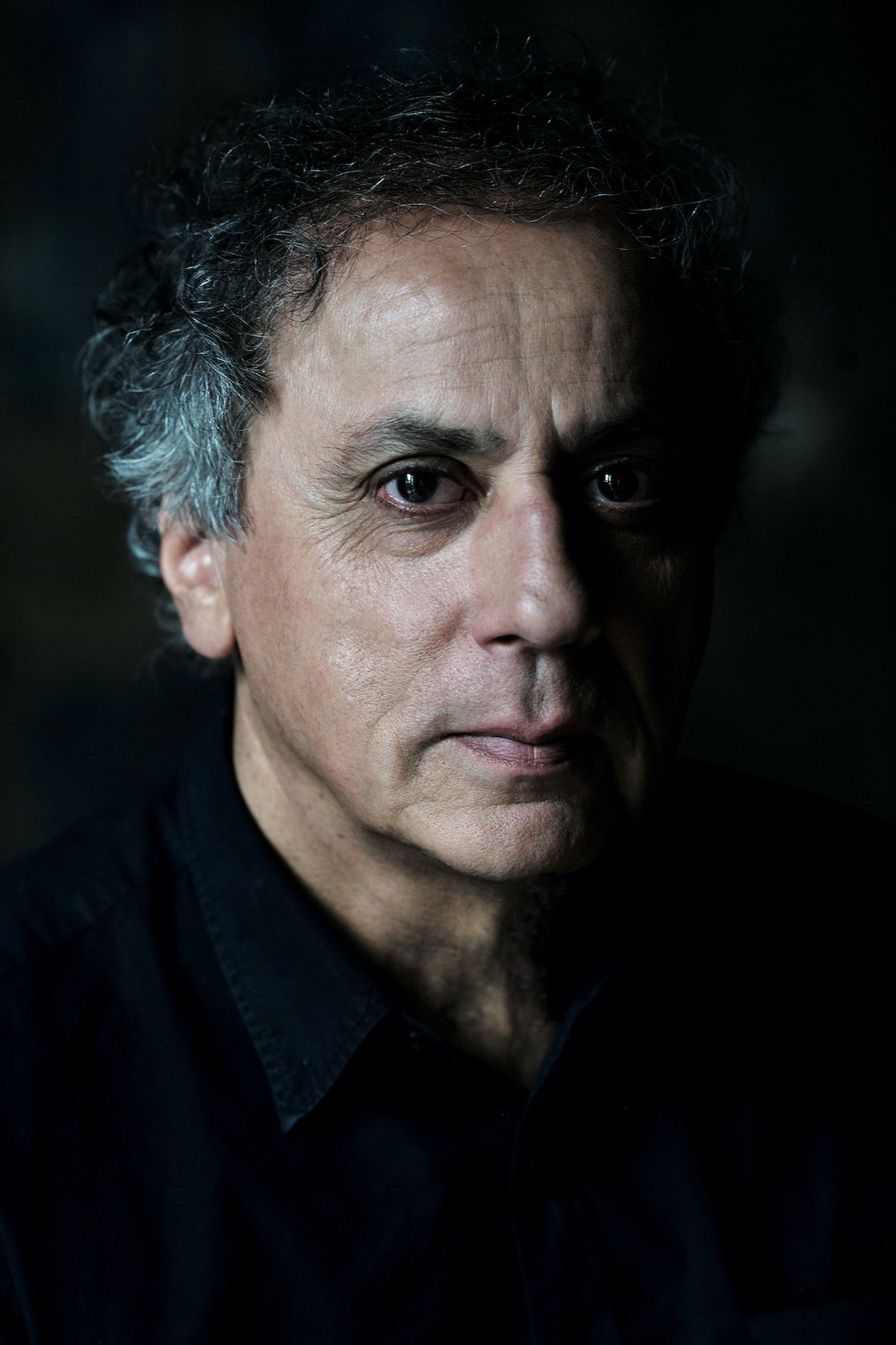 A man with graying hair looks into the lens.