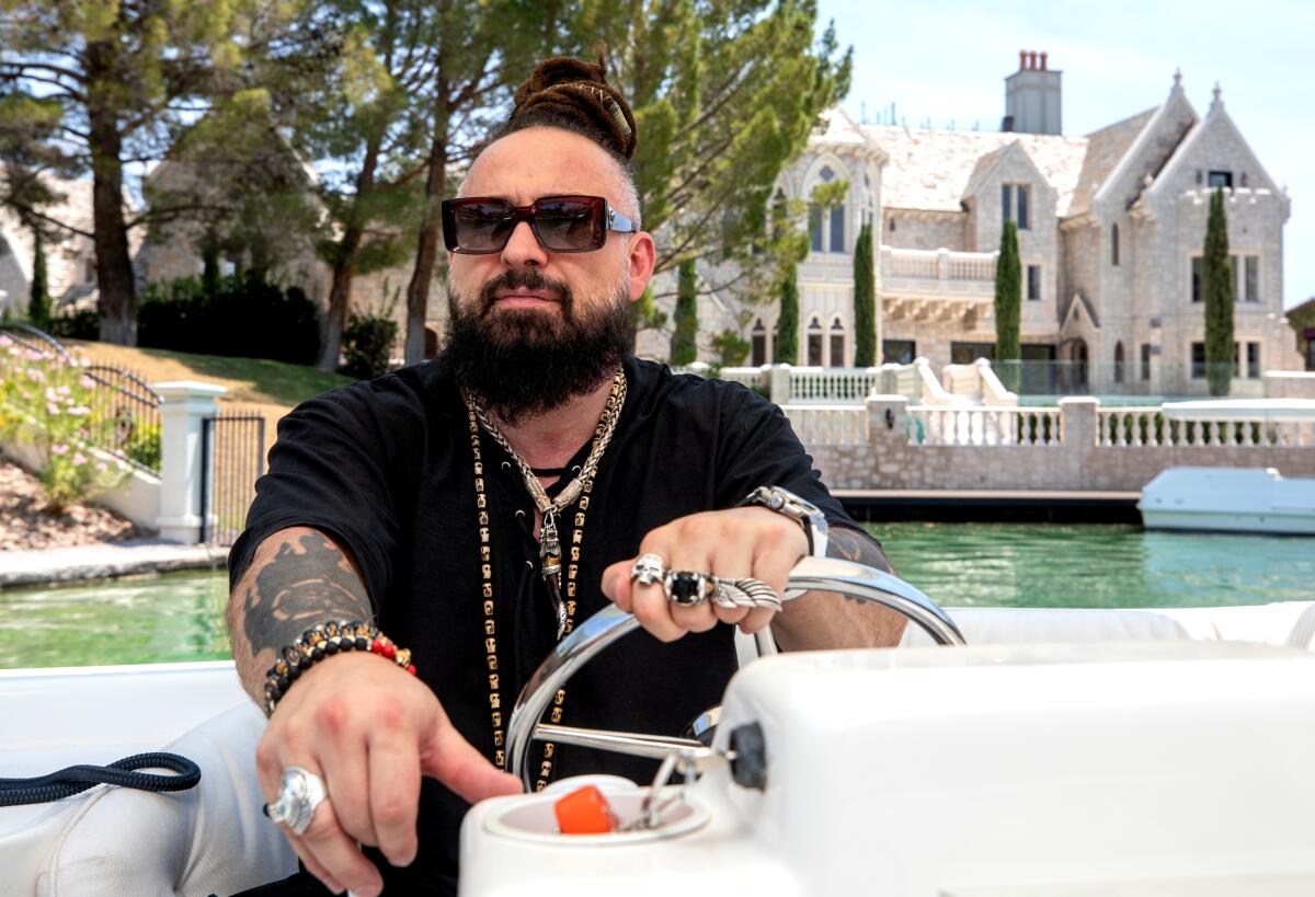 Man with dreadlocks and sunglasses sitting on a boat with a castle in the background