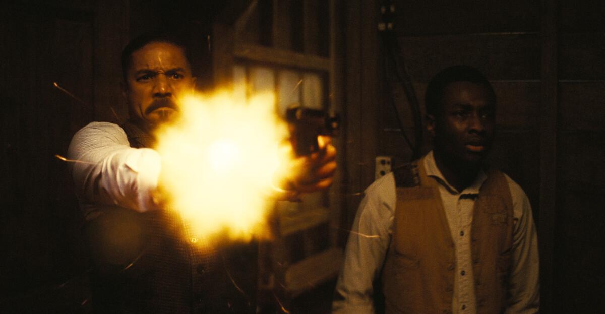 A man stands back while firing a gun