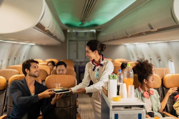 Air steward takes care of passengers on plane