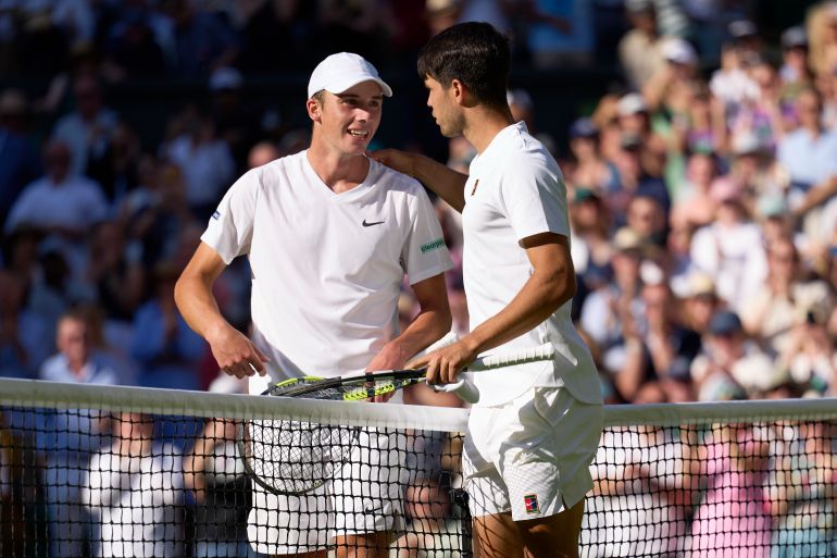 Oliver Target of Great Britain at the net with Carlos Alcaraz of Spain during the Gentlemen's Singles second round match on day three of The Championships Wimbledon 2025