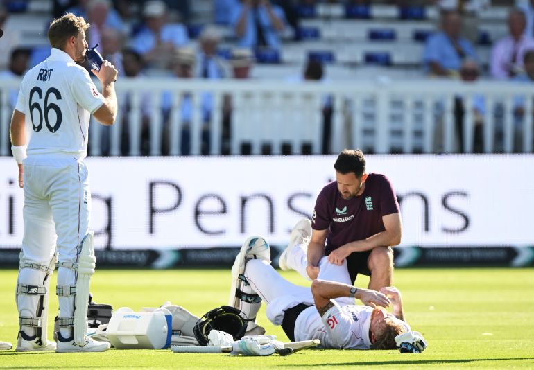  Ben Stokes of England receives treatment for an injury as Joe Root of England takes a drink