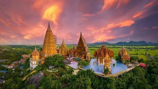 Aerial Drone Sunset Scene with Beautiful Sky of tham sua Temple near the City of Kanchanaburi in Cen