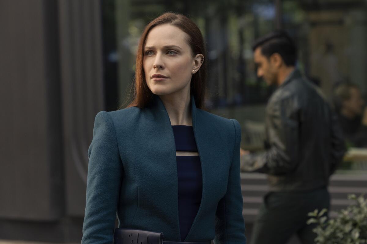 A woman with red hair in a dark blue outfit.