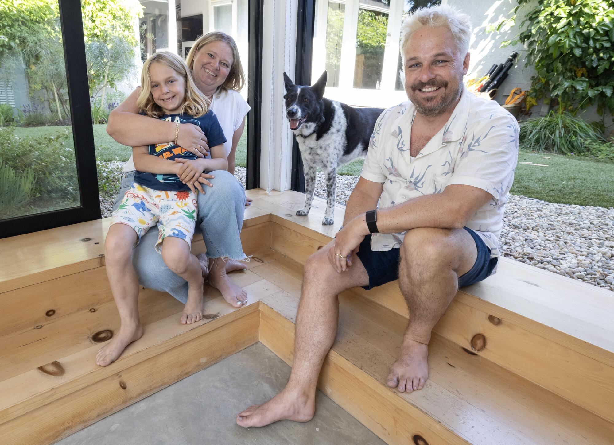 Frith Dabkowski and Will Burroughs sit with their son Jack and dog Banjo