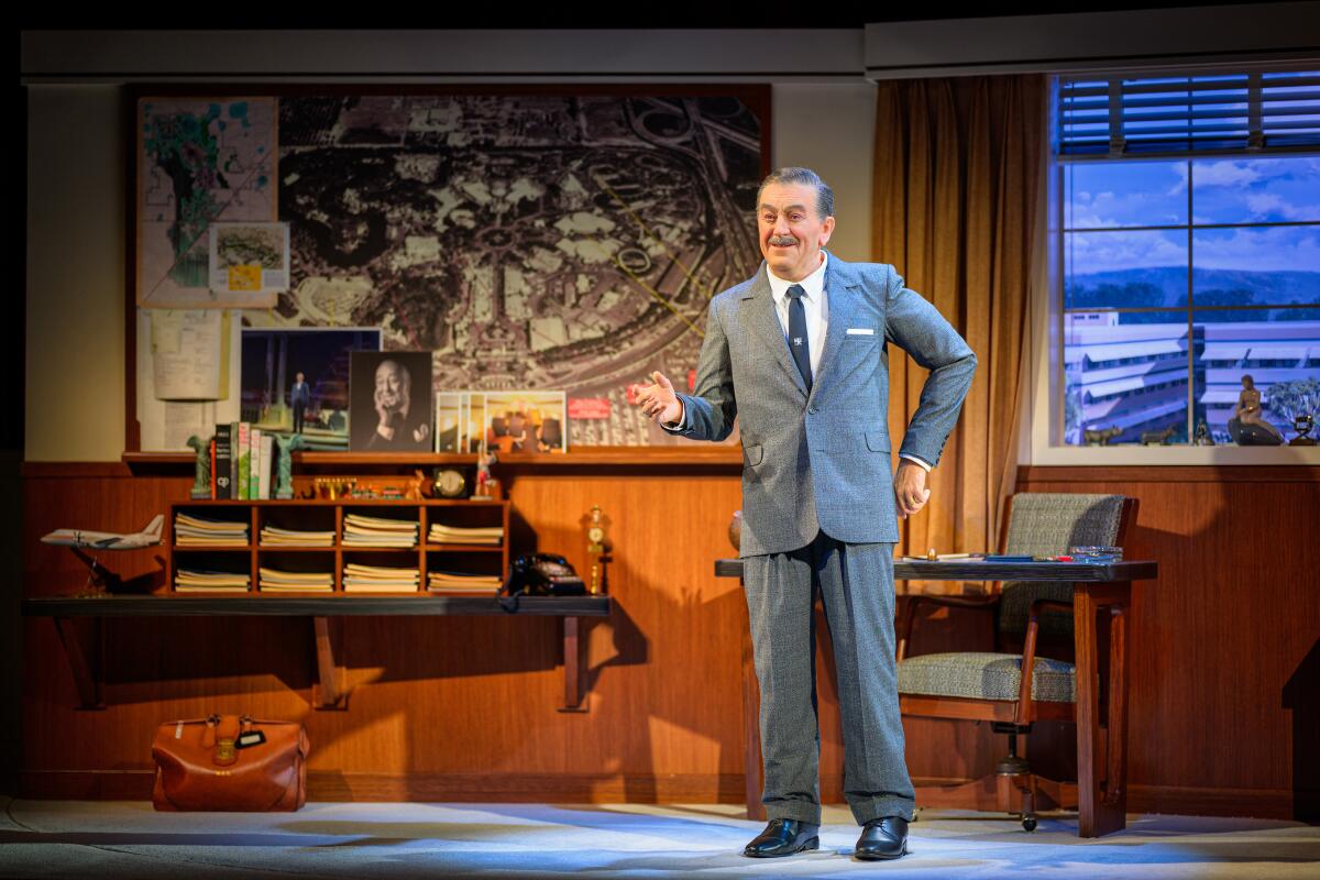 An animatronic of Walt Disney standing with his hand on his hips. 