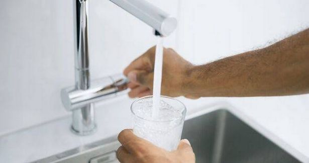 Man filling glass of water