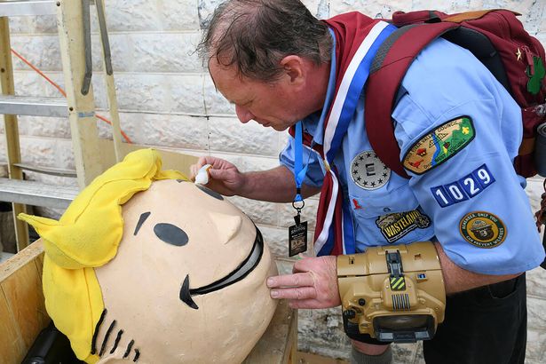 Brian McLaughlin from Los Angles touches up his "Vault Boy" head during the Fallout Fan Celebration Saturday, Nov. 16, 2024, in Goodsprings, Nevada. McLaughlin is with Fallout for Hope, a charity that benefits St. Jude's Ranch for Children. (Sam Morris/Las Vegas Review-Journal/Tribune News Service via Getty Images)