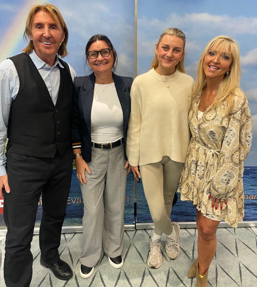 Group photo of four people standing in front of a Nik & Eva backdrop.