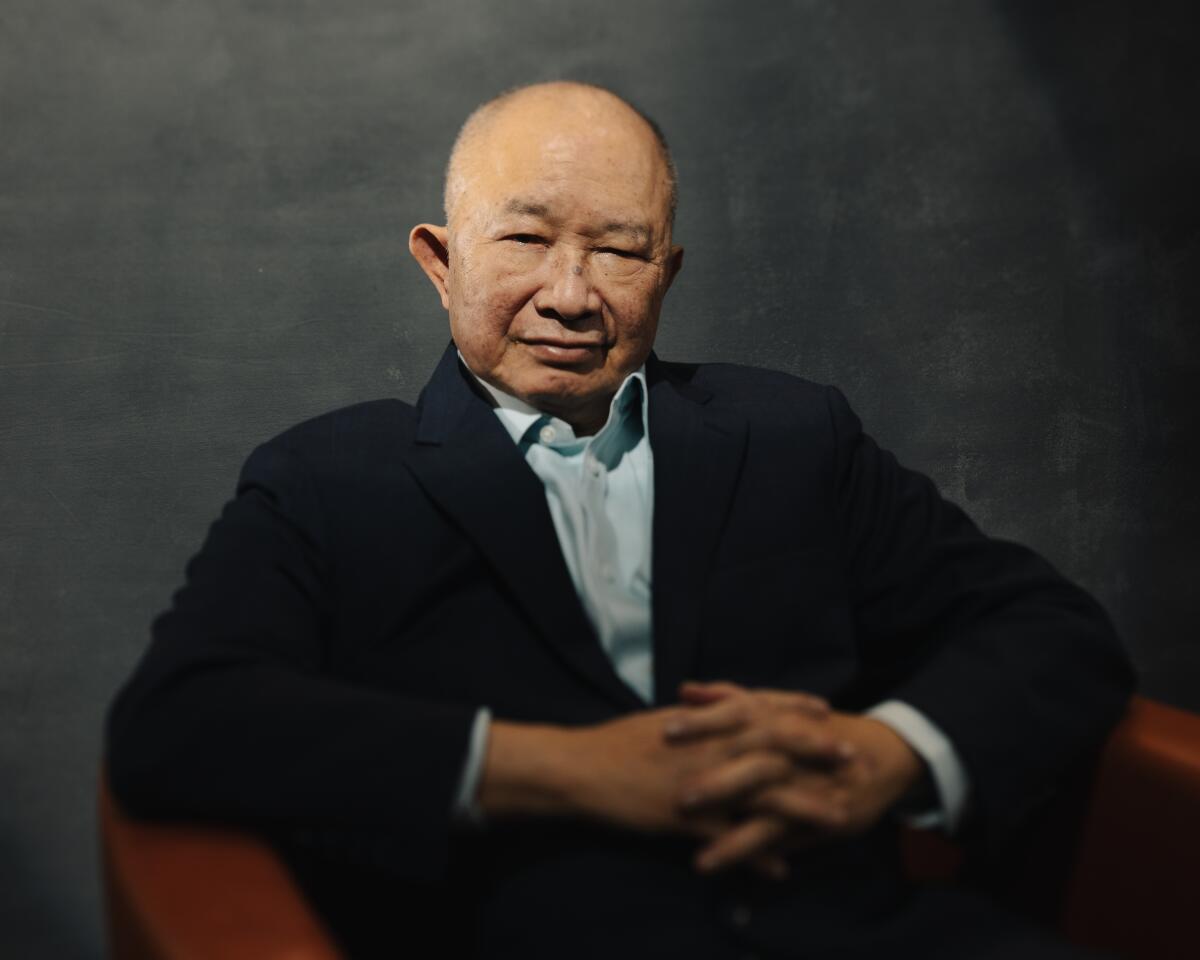 A serene man crosses his fingers and smiles.