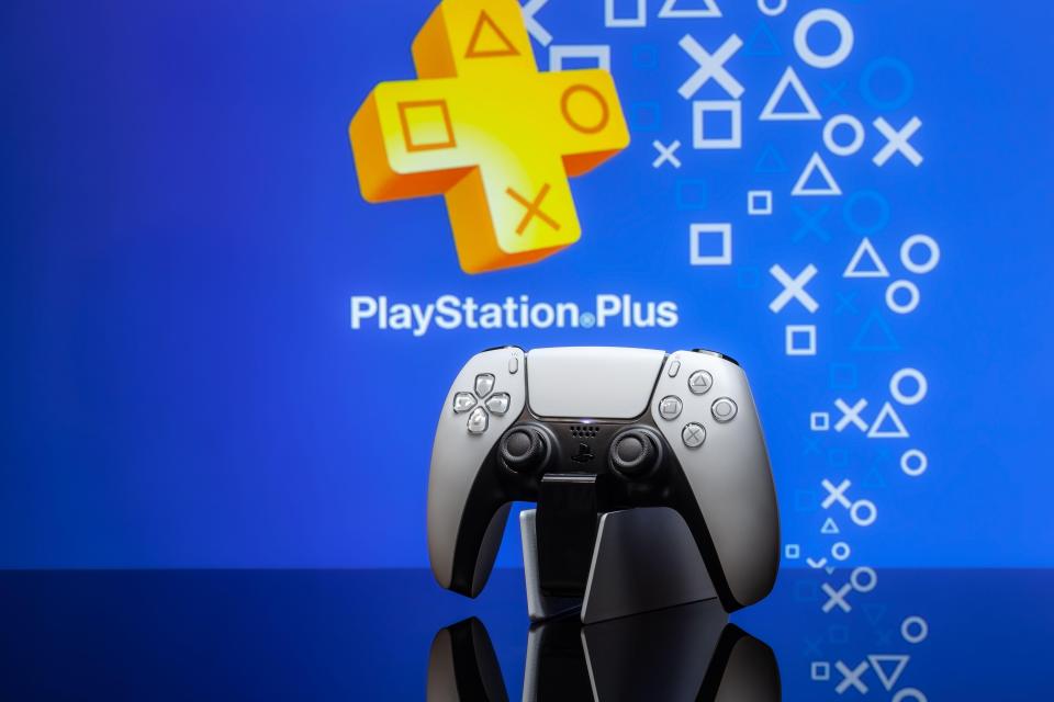 PlayStation 5 controller in front of PlayStation Plus logo.