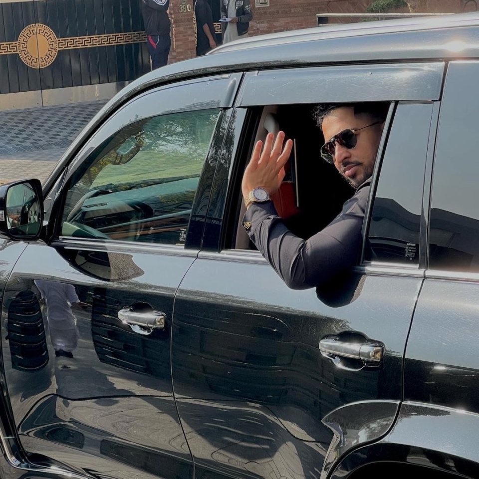 Salman Iftikhar waving from a car window.