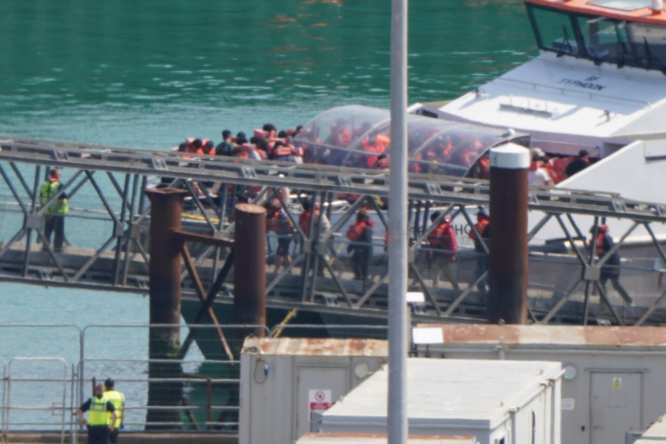 Migrants disembarking a boat in Dover.