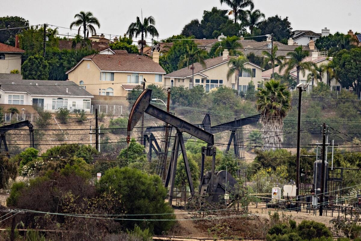 Homes sit a short walk from oil pumpjacks.