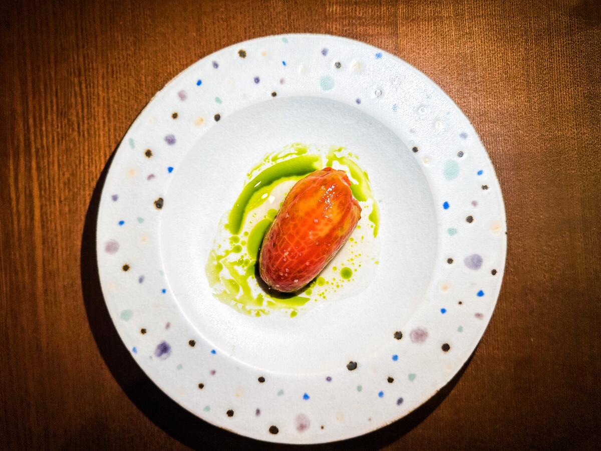 Marinated tomato with paprika, sardine broth and chervil oil at Maison Sota in Paris.