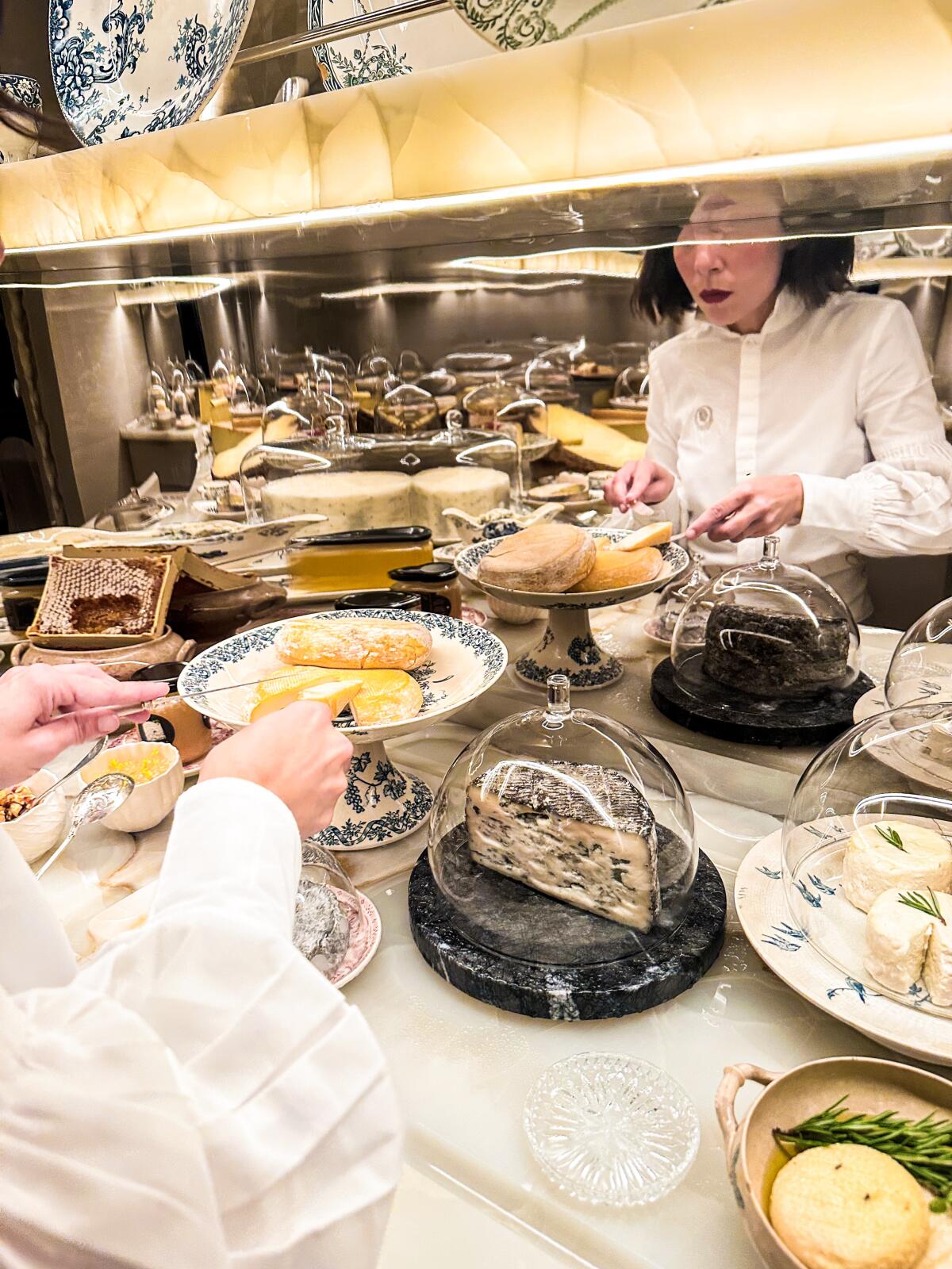 Composing a plate in the "cheese cupboard" at Plénitude in the Cheval Blanc hotel in Paris.