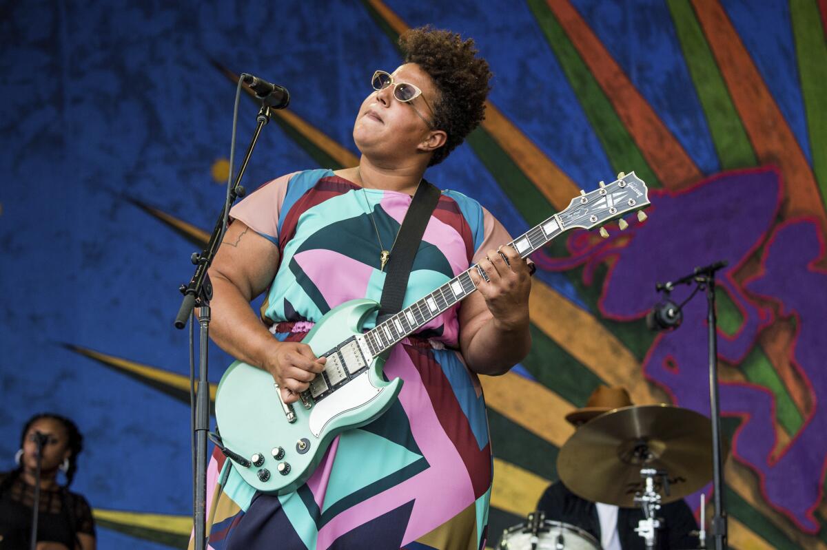 A woman with a guitar rocks out.